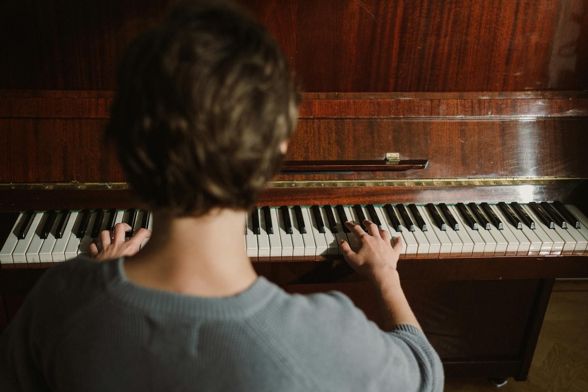 Apprendre le piano seul chez soi : bien démarrer pour éviter les pièges classiques — personne pratiquant le piano chez soi
