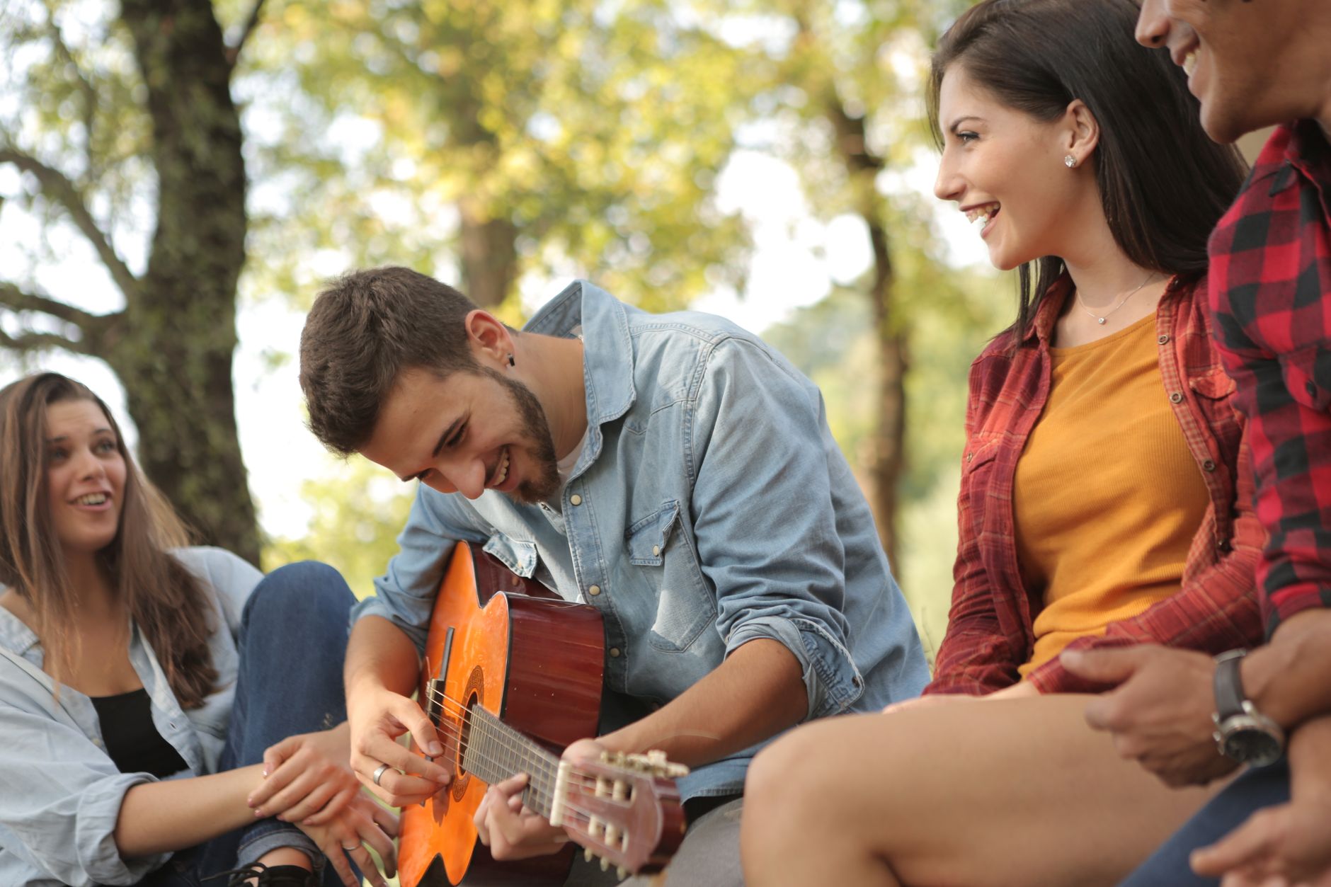 Les copains d’abord : contexte et paroles de chanson — guitariste chantant en plein air avec amis